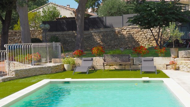 A swimming pool with a stone wall and a bench. - Le Mas de la Coquille (Castries)