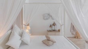 A bedroom with a canopy bed, white bedding, and a bedside table with lanterns. - Frattina 11 people (Rome)