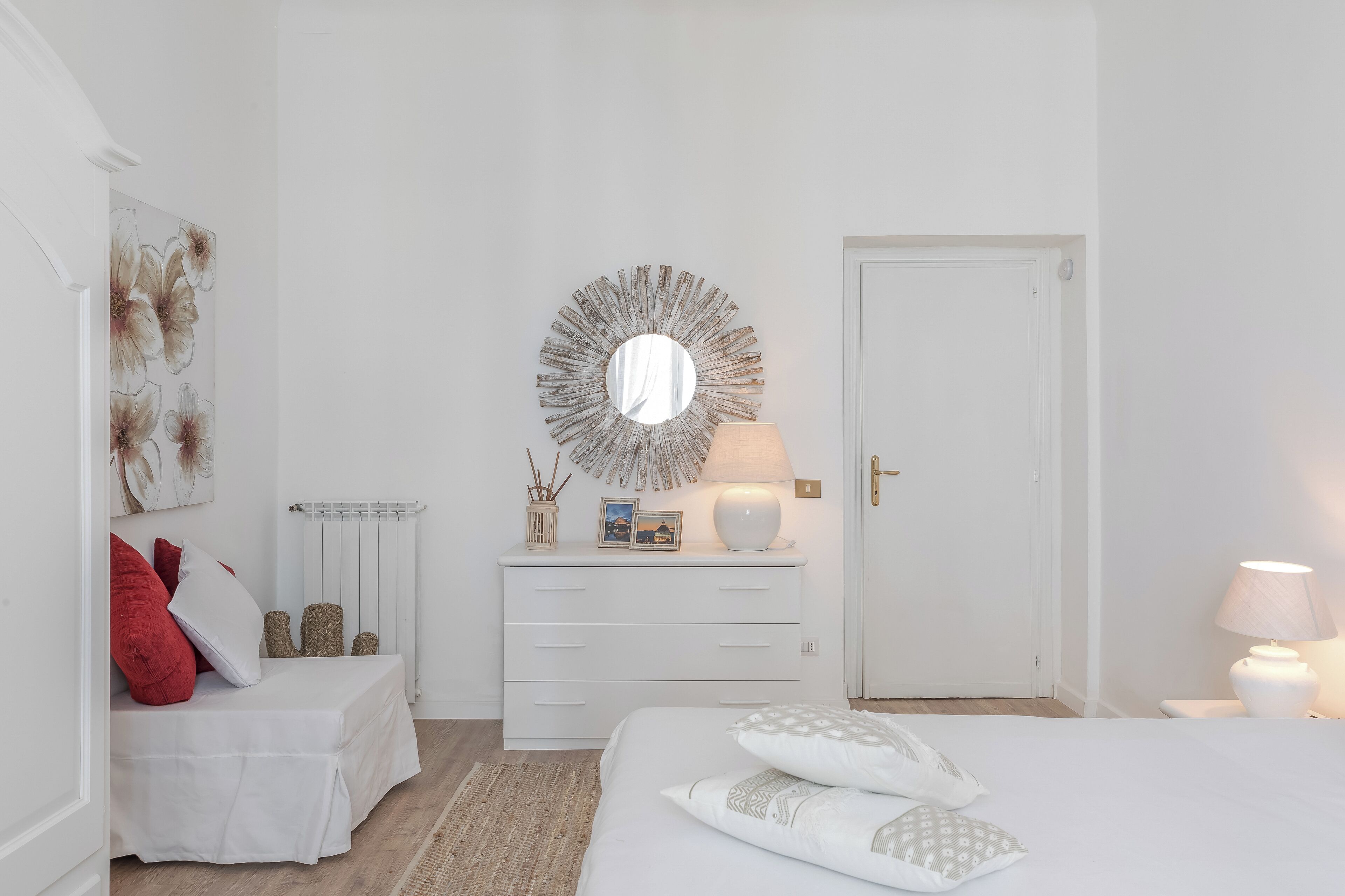 Ein schlicht eingerichtetes Schlafzimmer mit Bett, Nachttisch und Kommode.