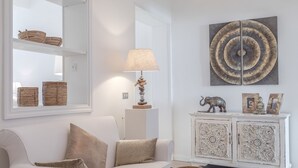 A modern living room with a white sofa, a lamp, decorative baskets, and a cabinet with intricate designs. - Frattina 11 people (Rome)