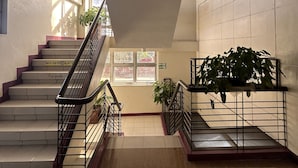 A modern interior with a staircase, tiled floors, and potted plants. - La Anclar Hotel (Davao)