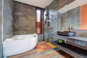 Ein modernes Badezimmer mit freistehender Badewanne, einer Duschkabine und einem großen Spiegel über dem Waschbecken.