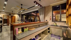 A modern hotel lobby with a reception desk, a ceiling fan, a fire extinguisher, and a large window with curtains. - Fishermen Pool Villa Samui (Chang Wat Surat Thani)