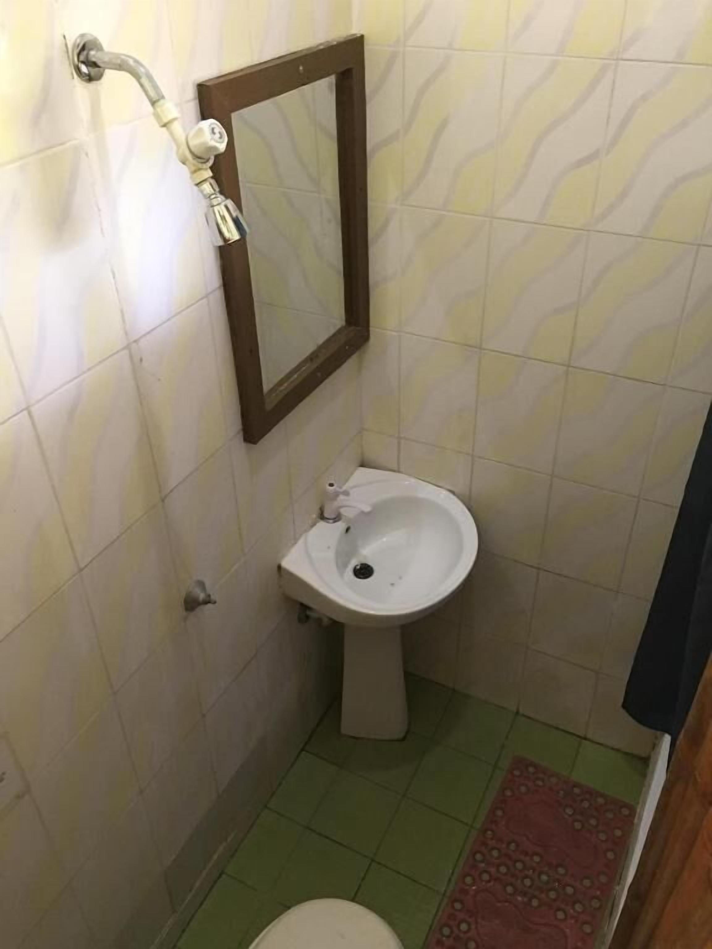 A small bathroom with a toilet, a bidet, and a mirror.