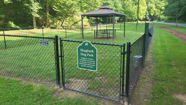 A fenced dog park with a gazebo and a sign indicating it is managed by Stanley Fence Co. - TN Whiskey - 3 BR w/ Hot Tub, Great View, Games, Pool and Resort Amenity Access! (Sevierville)