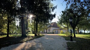 A gravel path leading to a building with a tiled roof, surrounded by trees and a clear sky. - Le Petit Comte' an Oasis of Calm with heated pool and hot tub in 2.5 acres (Bergerac)