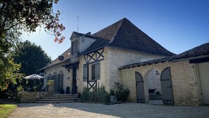 A stone building with a pitched roof, a satellite dish, and a gravel driveway. - Le Petit Comte' an Oasis of Calm with heated pool and hot tub in 2.5 acres (Bergerac)