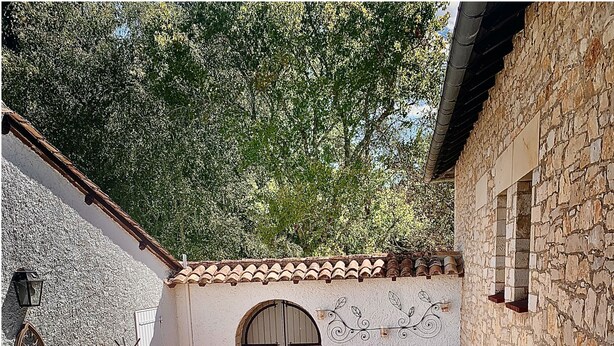 A stone-walled outdoor area with a hot tub, seating, and potted plants. - Le Petit Comte' an Oasis of Calm with heated pool and hot tub in 2.5 acres (Bergerac)
