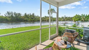 A balcony with a view of a river, a pool, and lush greenery. - 261 #5 Managed By Brampton Park (Deerfield Beach)