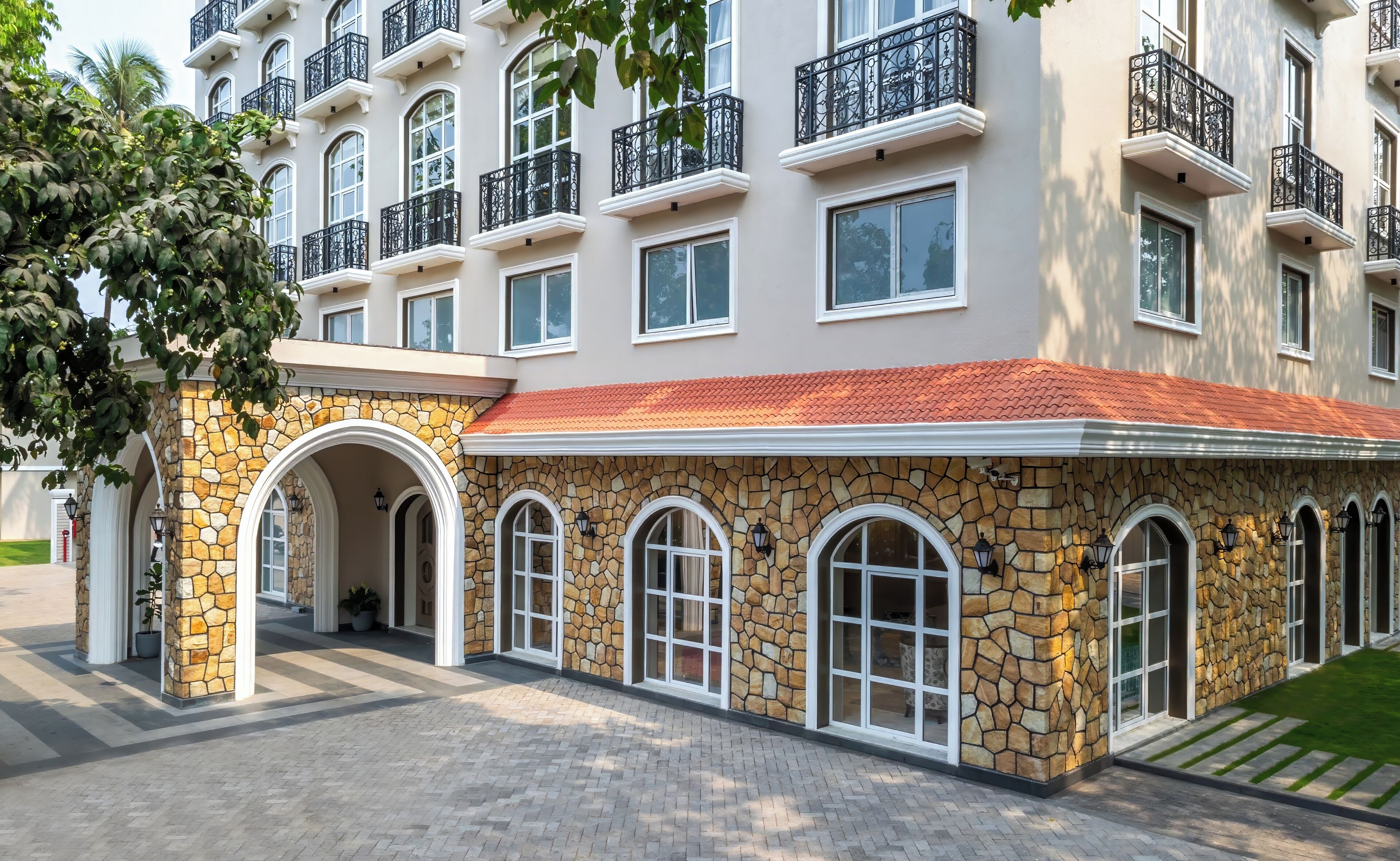 A multi-story hotel with stone facade, arched windows, and balconies.