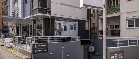 A modern building with a sign for 'Sienna' indicating it is a hotel. There are signs for 'PARKING' and 'GARAGE' with numbers.