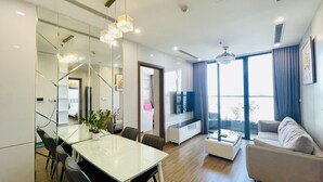 Un salon moderne avec un coin repas, de grandes fenêtres et un canapé.