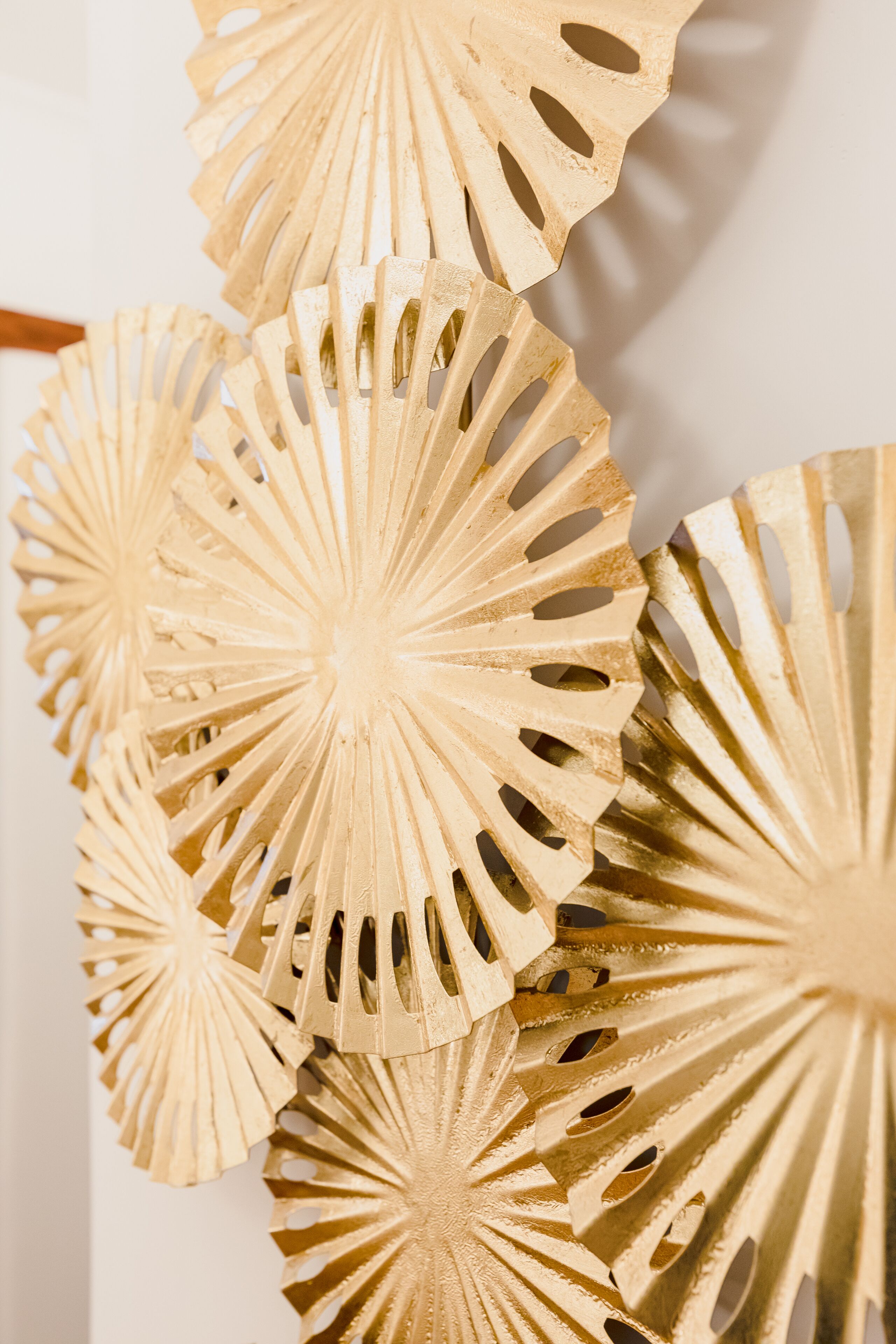 A close-up of a wall with multiple golden, circular, perforated wall decorations.