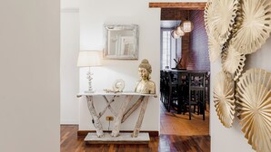 Un comedor con mesa de madera rústica, una estatua de Buda y un adorno de pared.