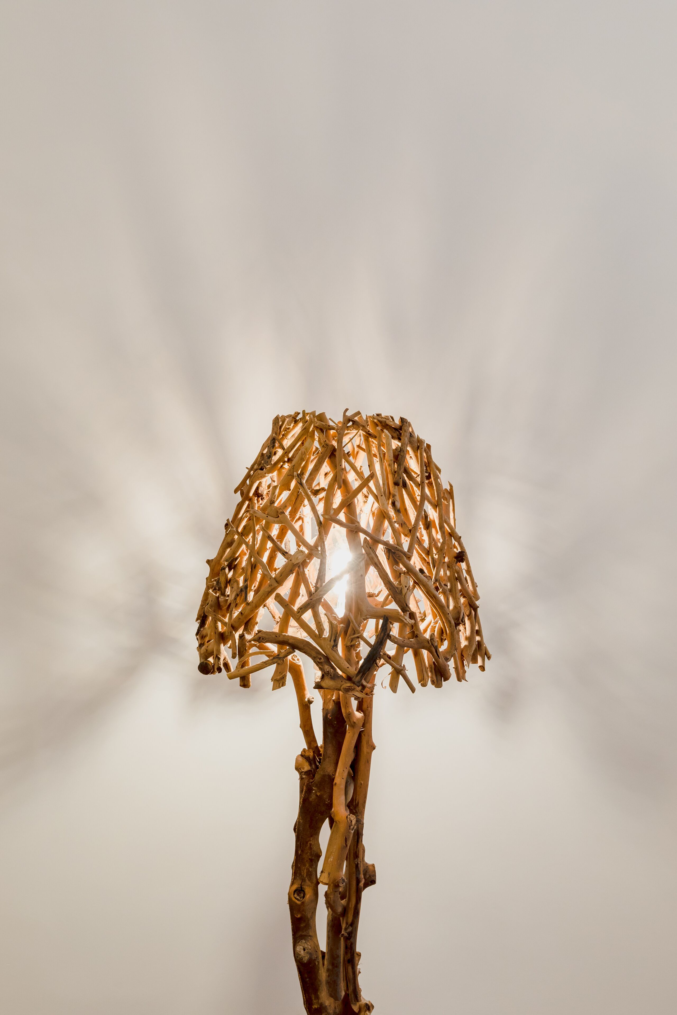 A lamp with a woven shade and a wooden base.