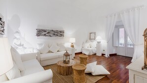 Una sala moderna con muebles blancos, un farol decorativo y una gran estatua de Buda.