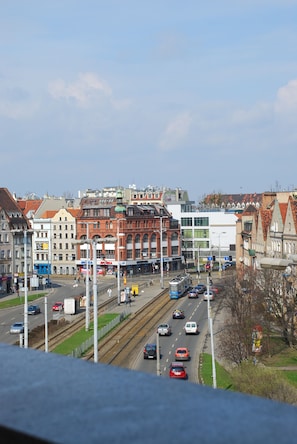 Une rue de la ville avec des immeubles, des voitures et un tramway.