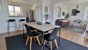 Ein moderner Wohnraum mit Essbereich, Küche und Sitzecke.