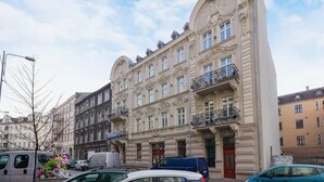 Un immeuble à plusieurs étages, doté d’éléments architecturaux raffinés, notamment des balcons et des moulures décoratives.