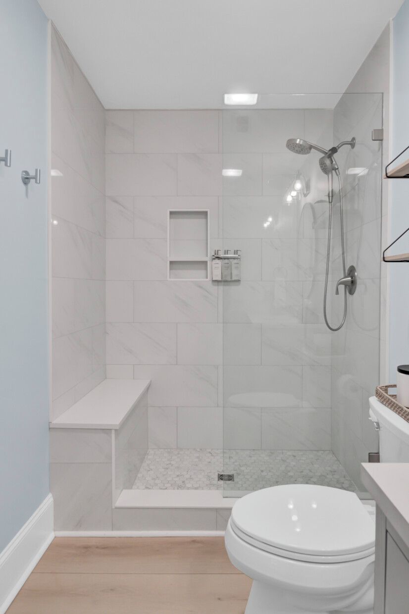 Une salle de bain moderne avec une douche à parois de verre, des toilettes et un meuble-lavabo avec un évier.