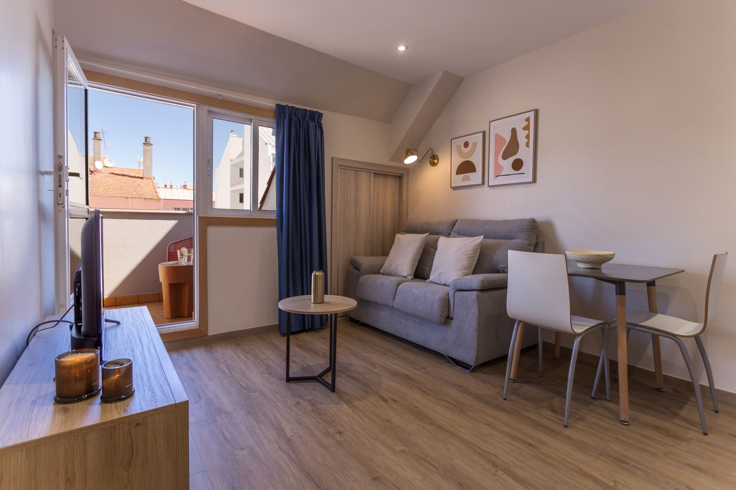 Ein modernes Wohnzimmer mit einer Couch, einem kleinen runden Tisch und einem Essbereich mit Stühlen.