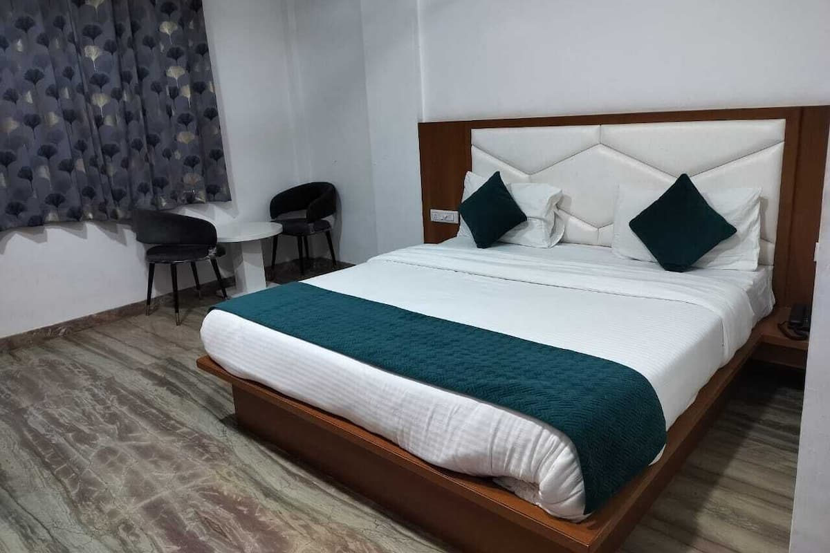 Ein ordentlich eingerichtetes Hotelzimmer mit einem großen Bett, einem Schreibtisch und einem Stuhl.