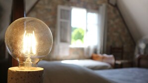 Ein Zimmer mit einer Steinsandsteinwand, einem Bett und einer Lampe.