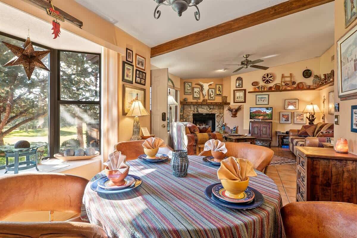 Un comedor con una mesa redonda, sillas y una chimenea.