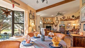 A dining area with a round table, chairs, and a fireplace.