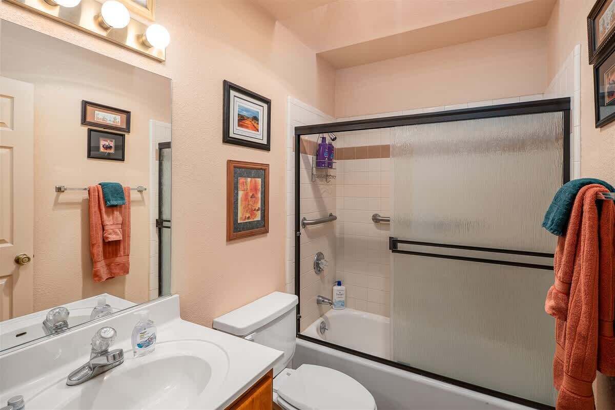 A bathroom with a sink, toilet, and glass-enclosed shower.