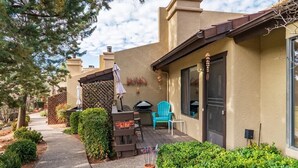 A patio with outdoor furniture, a grill, and a covered seating area.