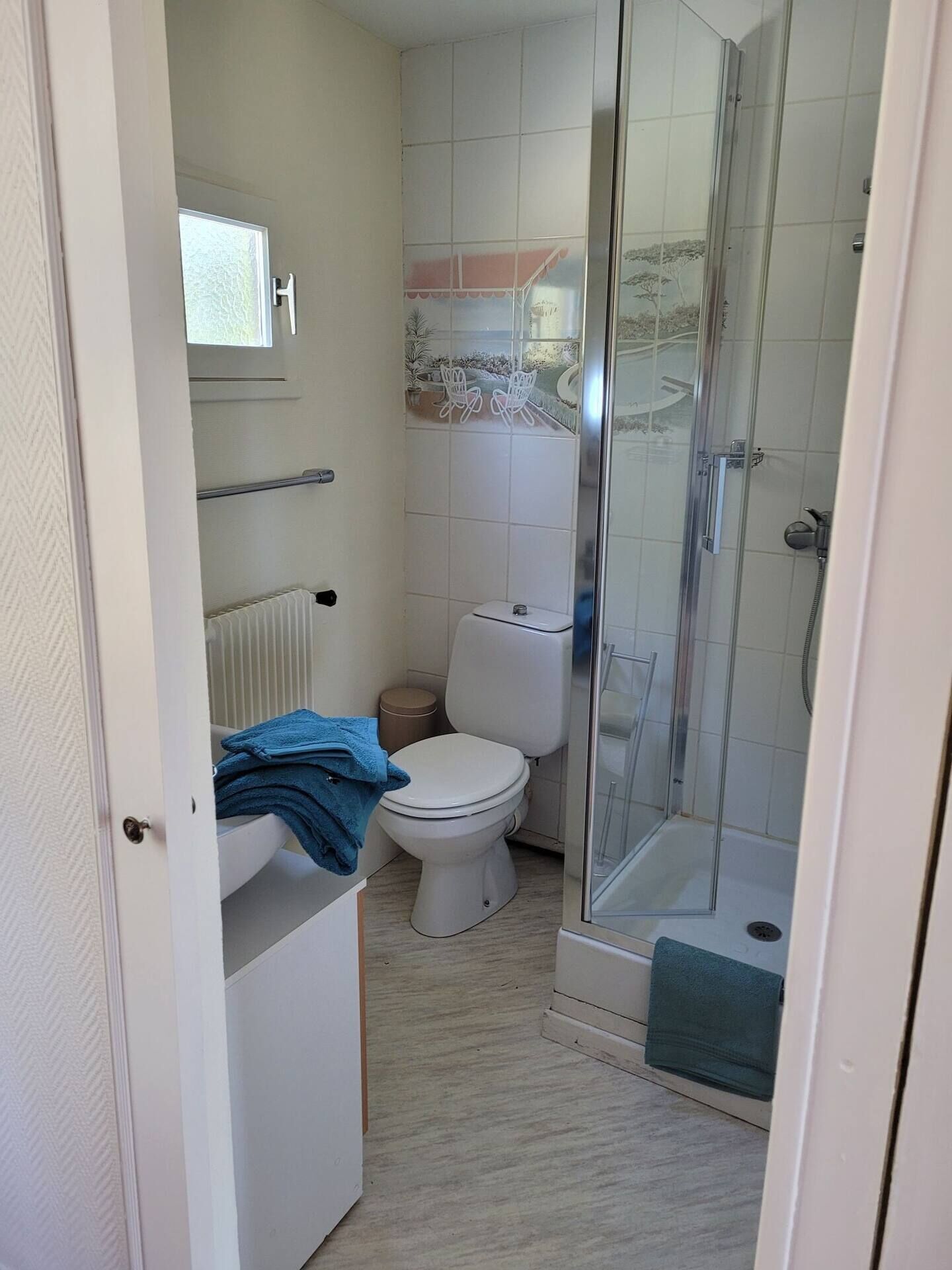 A bathroom with a toilet, a shower, and a sink.
