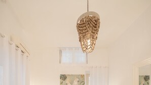 A living room with a white sofa, a round coffee table, and a hanging light fixture. - Campo Viola 10 people (Rome)