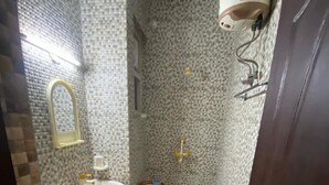 Un baño pequeño con inodoro, lavamanos y calentador de agua instalado en la pared.