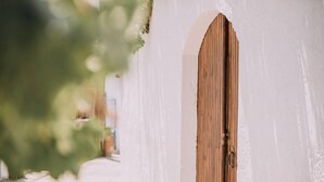 A white building with a wooden door and a small window. - Melody House in Roustika (Rethymno)