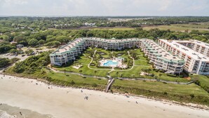 Un resort con piscina central, varias edificaciones y zona de playa.