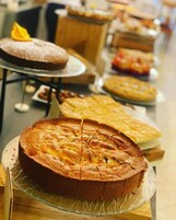 Diversas opciones de pastelería y productos horneados presentados en una mesa de buffet.