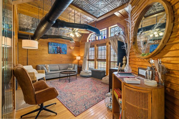 Relax in a cozy space with a comfortable seating area, wooden side table, and large window.