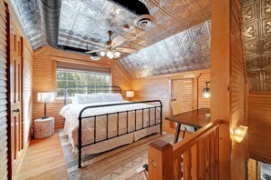 Relax in this inviting bedroom with a comfortable metal bed, wooden headboard, and ceiling fan.