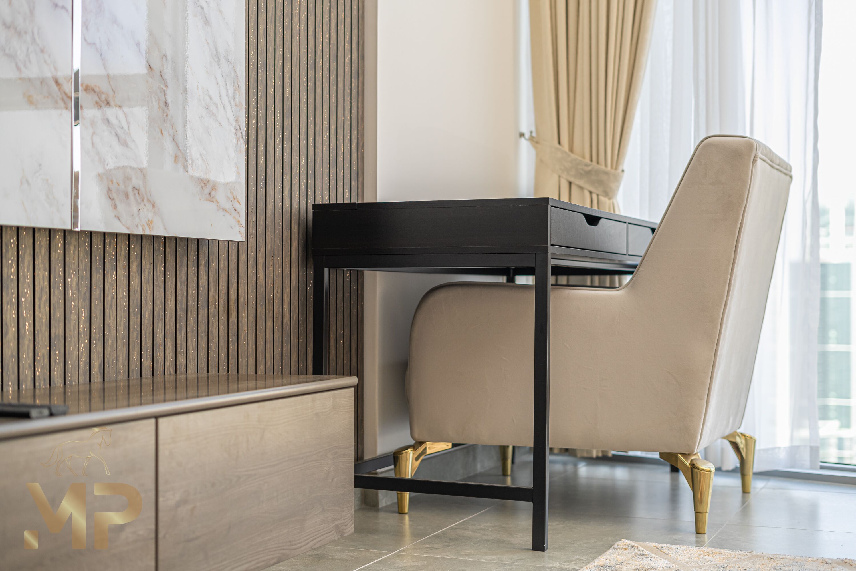 A modern interior with a wooden panel wall, a marble accent wall, a black table, and a beige upholstered chair with gold legs.