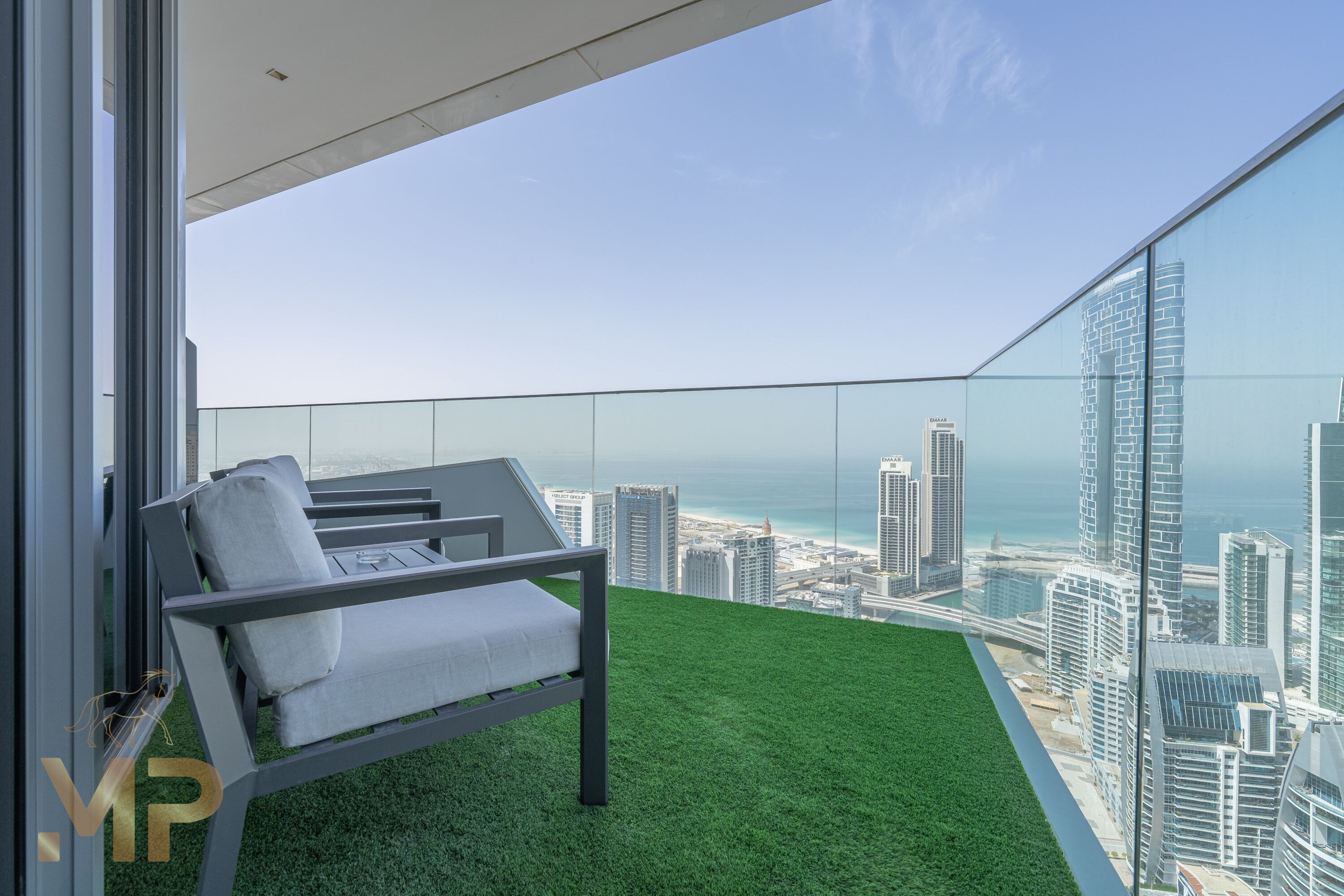 A balcony with a view of a cityscape and the sea.