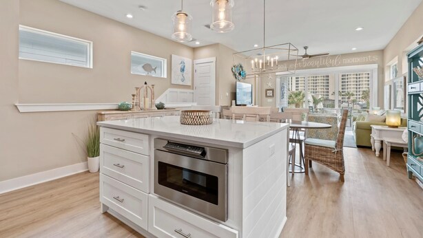 A spacious kitchen with a large island, modern appliances, and pendant lighting. - Luxury Home 1 Block to Beach with Game Room (Jacksonville Beach)