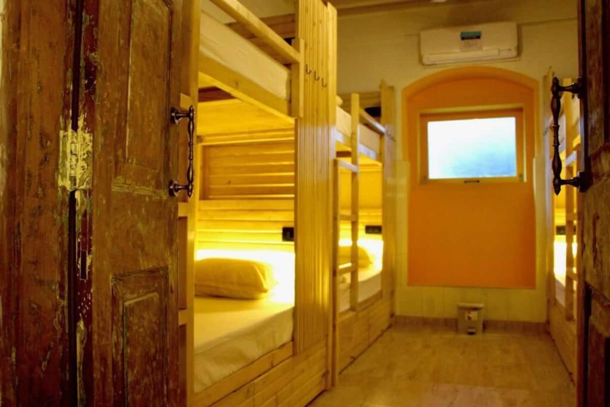 Una habitación con literas, una ventana y una puerta.