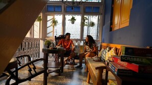A cozy room with a dining table, chairs, a sofa, and a collection of board games.