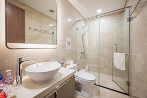 Une salle de bain moderne avec un grand lavabo blanc, des toilettes et une douche à parois de verre.