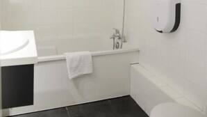 A bathroom with a white sink, a bathtub, a toilet, and a hand dryer. - Hôtel Aerel Aéroport Blagnac (Blagnac)