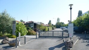 A gated parking area with a sign indicating payment is required. - Hôtel Aerel Aéroport Blagnac (Blagnac)