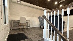 A staircase with white balusters and a dark handrail leading to a landing. - Quaint, all new loft apt. located in a quiet country setting, minutes from town. (Fort Pierre)