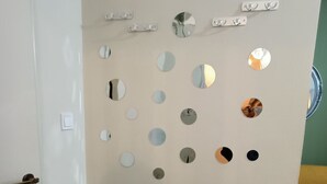 Ein Zimmer mit einer Wand, die mit runden Spiegeln verziert ist, und einer Tür mit Messinggriff.