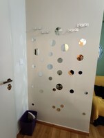 A room with a wall decorated with circular mirrors and a door with a brass handle.